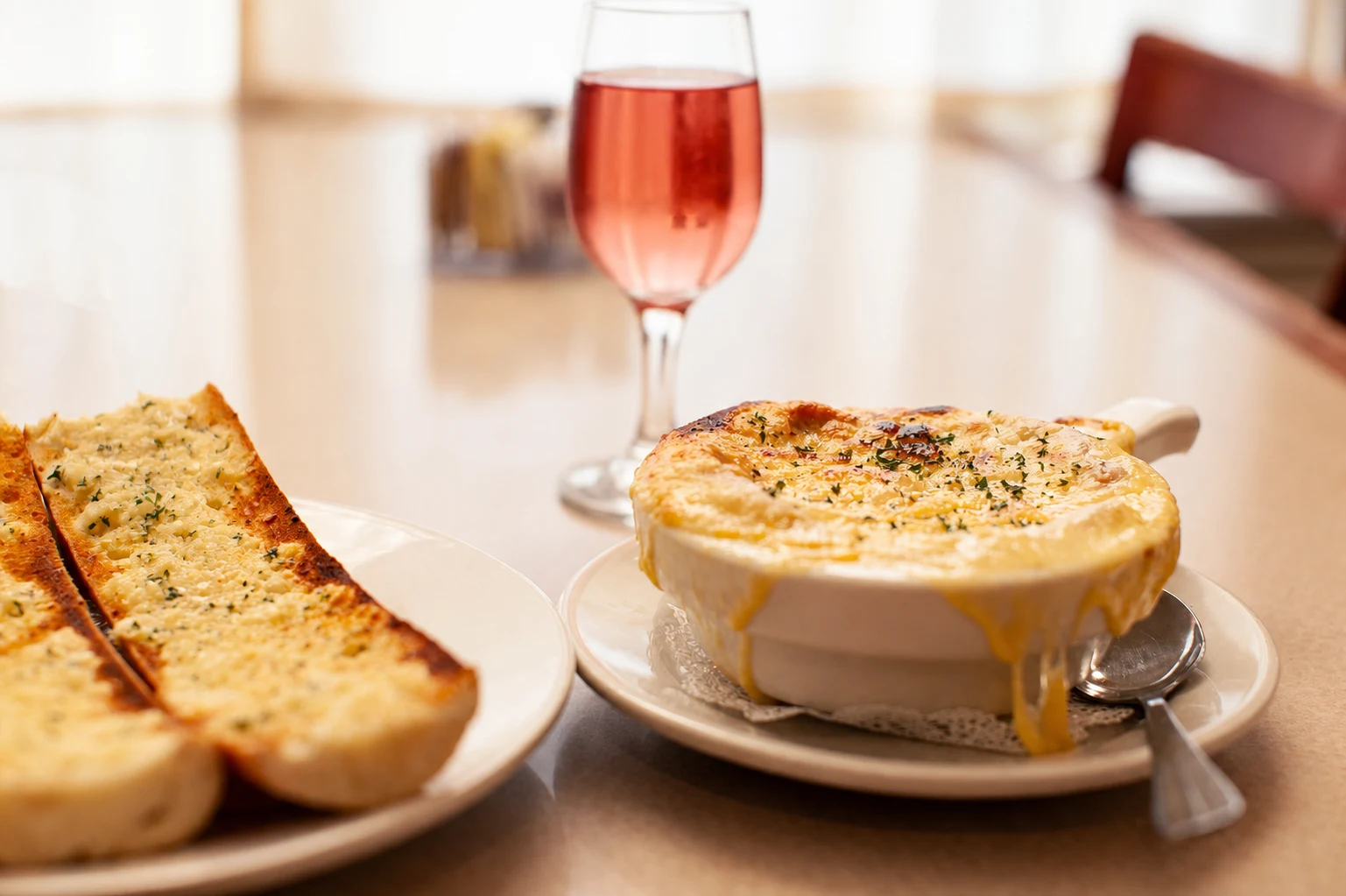 French onion soup with toasted baguette and a glass on the table